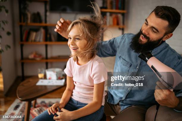 father drying and styling little daughter's hair at home - drying stock pictures, royalty-free photos & images