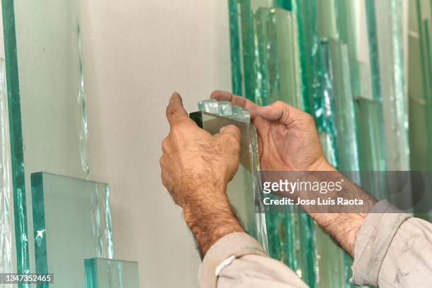 hands of a glass factory worker. - glass factory stock-fotos und bilder