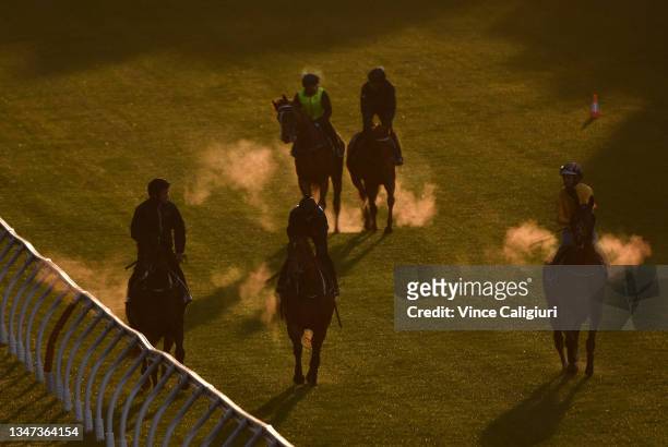 Riders and horses are seen after galloping during the Breakfast with the Best trackwork session at Moonee Valley Racecourse on October 19, 2021 in...
