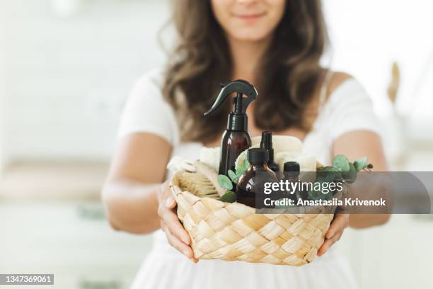 woman's hands with basket with various items and ingredients for eco home cleaning and house plants. - cleaning agent stock pictures, royalty-free photos & images