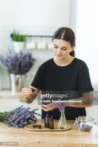 woman hands holding pipette of essential lavender oil. - apothecary bottle stock pictures, royalty-free photos & images