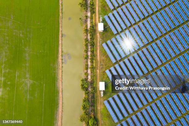 aerial view over solar cells energy farm in countryside landscape - phenomenon stock-fotos und bilder