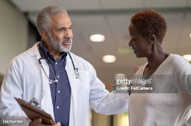 doctor giving a patient good news - person of colour stock pictures, royalty-free photos & images