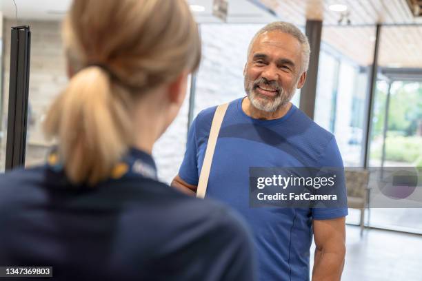 showing a member to his fitness class - gym receptionist stock pictures, royalty-free photos & images