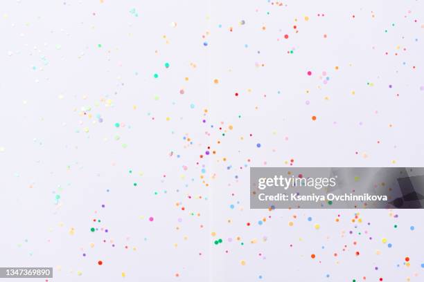 white background with scattered colorful confetti. holiday pattern wallpaper. flat lay, top view. party arrangement with copy space for text - karneval feier stock-fotos und bilder