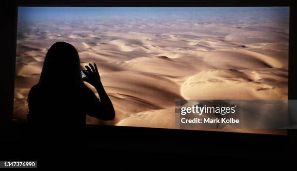 Viewer takes a photo of the work "diamond sea" during an exhibition preview of Doug Aitken: New Era at Museum of Contemporary Art on October 19, 2021...