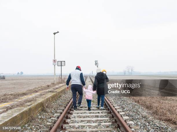 Family walking on track. Immigrants. Italy.