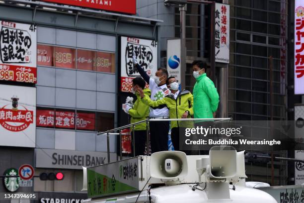 Japan Innovation Party leader Ichiro Matsui , party candidate Hidetaka Inoue wave to voters from election campaign car during the official election...