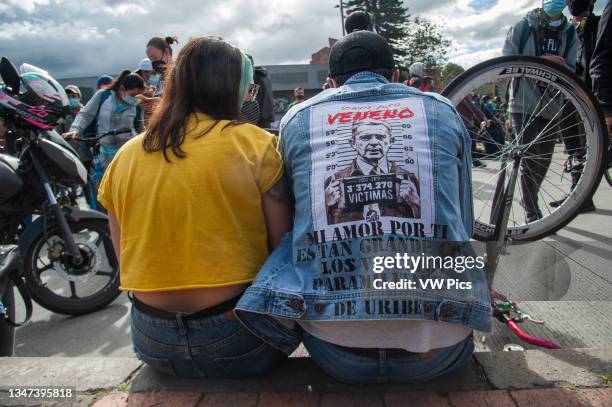 Demonstrator uses a jacket with an image of Alvaro Uribe jailed as thousands protest in northern Bogota, Colombia on May 12, 2021 against the cases...