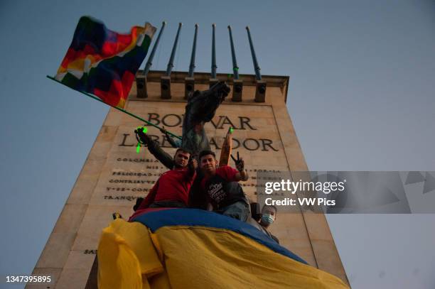 Demonstrators take the Simon Bolivar statue at Monumento a los Heroes in Northern Bogota with Colombian and indigenous flags as Colombia enters its...