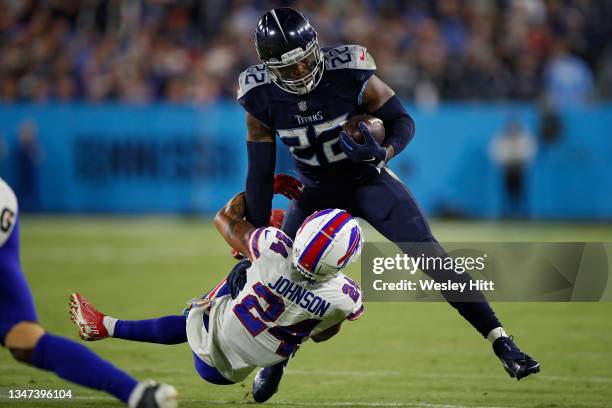 Running back Derrick Henry of the Tennessee Titans rushes in front of cornerback Taron Johnson of the Buffalo Bills during the second half at Nissan...