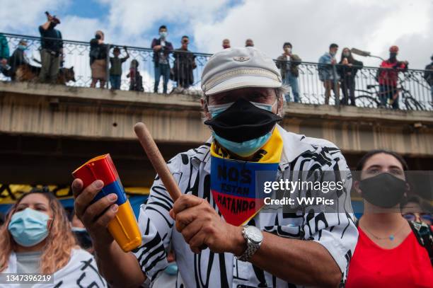 Demonstrator plays a cowbell as thousands protest in northern Bogota, Colombia on May 12, 2021 against the cases of police brutality that are at...
