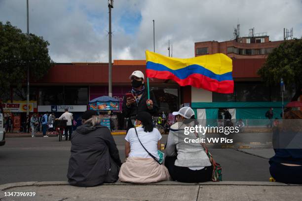 Demonstrator waves a Colombian flag as thousands protest in northern Bogota, Colombia on May 12, 2021 against the cases of police brutality that are...