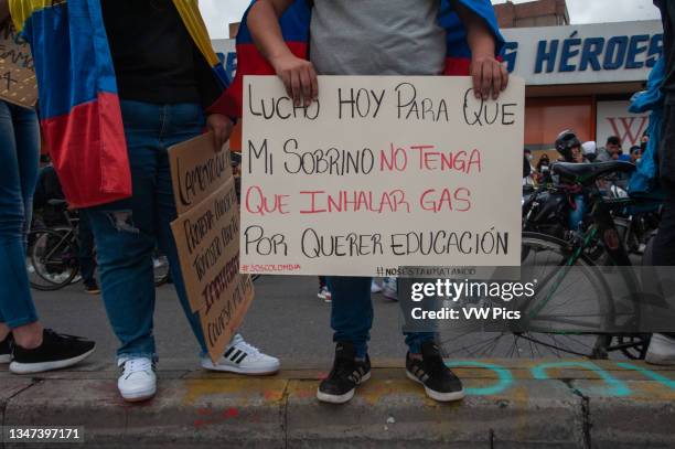 Demonstrator holds a sign that reads 'I fight today for my nephew so he doesn't has to breath tear gas for demanding for his education' as thousands...