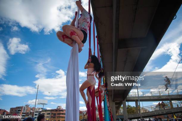Demonstrators hang from cloths on a bridge as a performance of to the ones dead in the protests as Colombia enters its 4th week of anti-government...