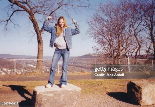 vintage photograph of confident woman flexing muscles, 2000s style y2k fashion - pantalon à pattes d'éléphant photos et images de collection