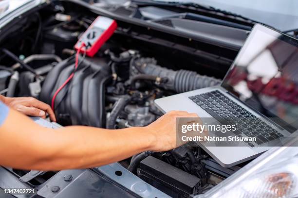 mechanic man using laptop examining tuning fixing repairing car - mechanic computer stock pictures, royalty-free photos & images