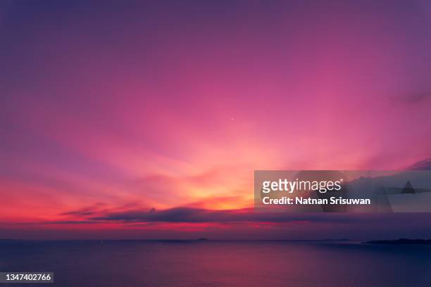 a cloudy and colorful sunset on the ocean - cielo romantico foto e immagini stock