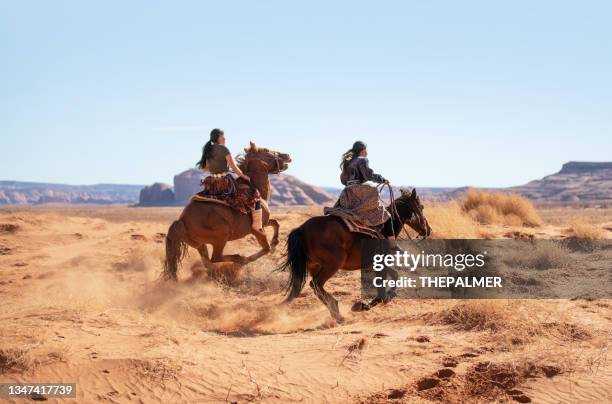 navajo girls sister galloping on horses at monument valley - horseback riding arizona stock pictures, royalty-free photos & images