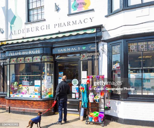 Aldeburgh pharmacy shop, Aldeburgh, Suffolk, England, UK traditional shop frontage and window display.