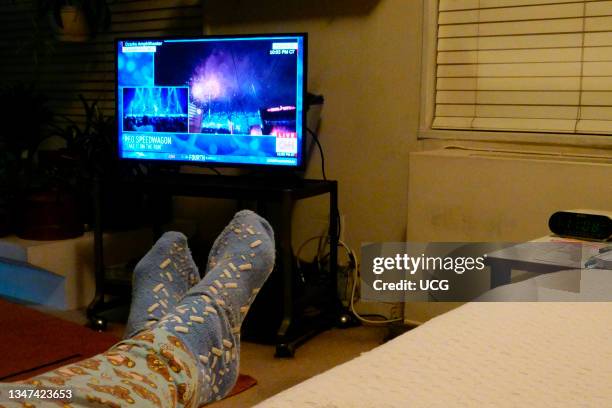 Feet up of person watching the Macy's fourth of July fireworks on TV.