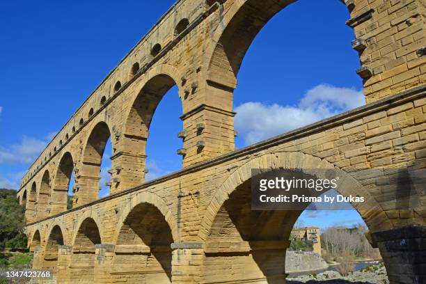 The Ancient Roman Pont du Gard aqueduct and viaduct bridge over the River Gardon, the highest of all ancient roman bridges, near to Nimes in the...