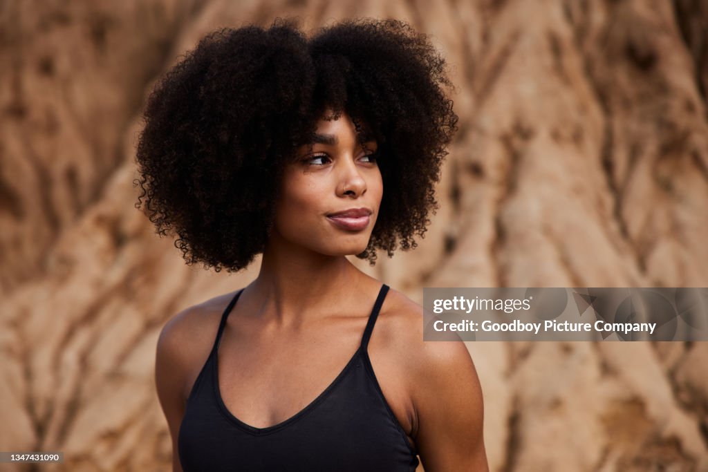 Femme en forme debout à l’extérieur après une course de sentier en fin d’après-midi