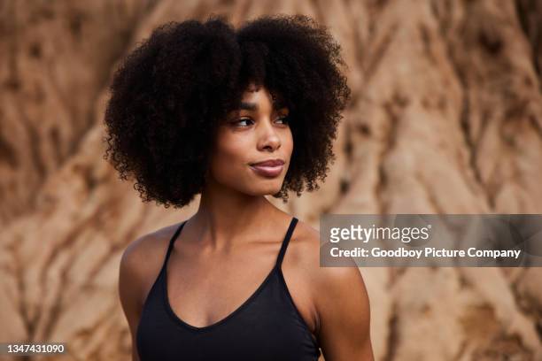 fit woman standing outdoors after a late afternoon trail run - curly hair imagens e fotografias de stock