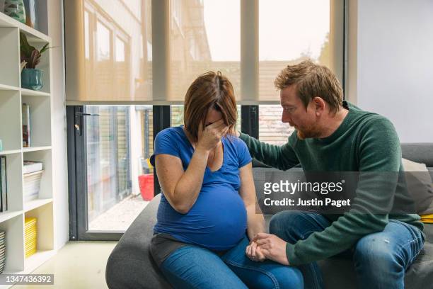 man comforts his upset pregnant wife - mad husband stock pictures, royalty-free photos & images
