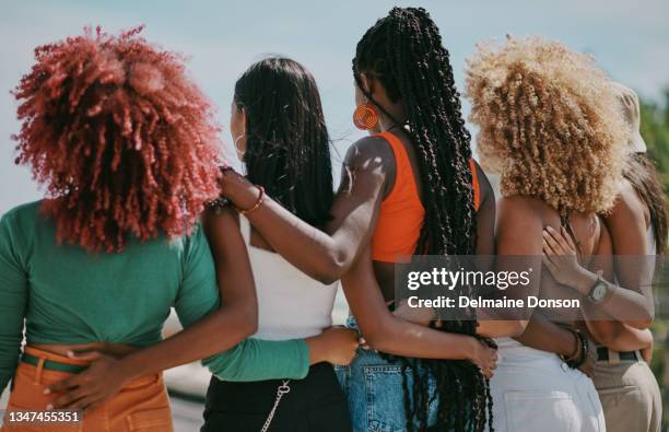shot of a group of friends embracing in the city - curly hair back stock pictures, royalty-free photos & images