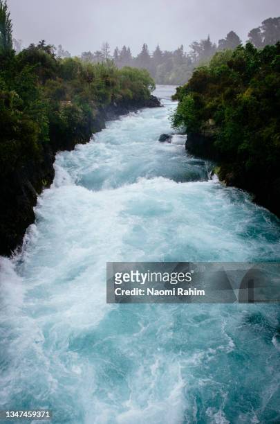 powerful huka falls, waterfall feeding a hydroelectric river in new zealand - corredeira rio - fotografias e filmes do acervo