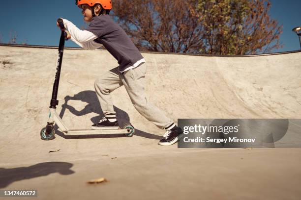 boy skating on scooter in skate park - kinder kickboard stock-fotos und bilder