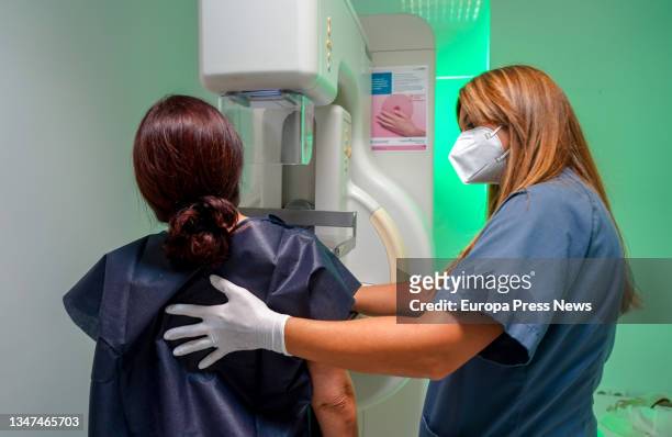 Lady with the help of a nurse gets a free mammogram at Quironsalud Infanta Luisa for the International Breast Cancer Day on October 19, 2021 in...