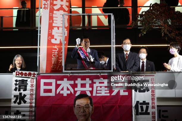 Japan Communist Party candidate Tadashi Shimizu speaks to voters from campaign car during the official election party campaign for the upcoming lower...