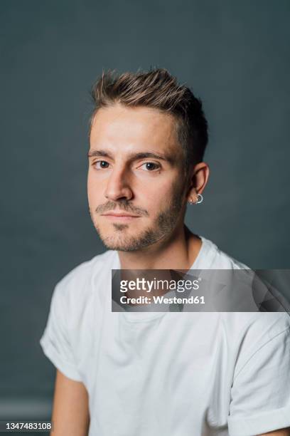 young man with piercing in studio - boucle d'oreille photos et images de collection