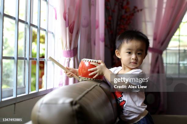 asian toddler - alex drumming 個照片及圖片檔