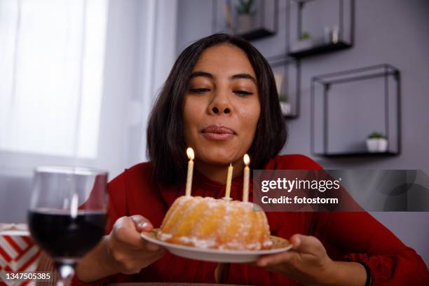 young woman blowing candles on her birthday cake - blowing out candles pov stock pictures, royalty-free photos & images