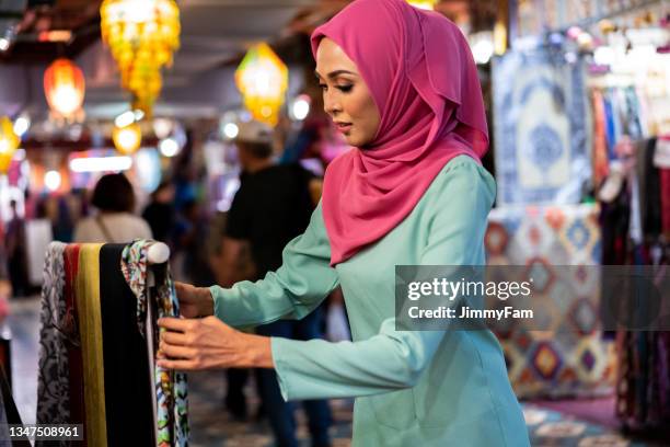 attractive malay female shop owner preparing her ware for ramadan at market bazaar. - silk scarves stock pictures, royalty-free photos & images