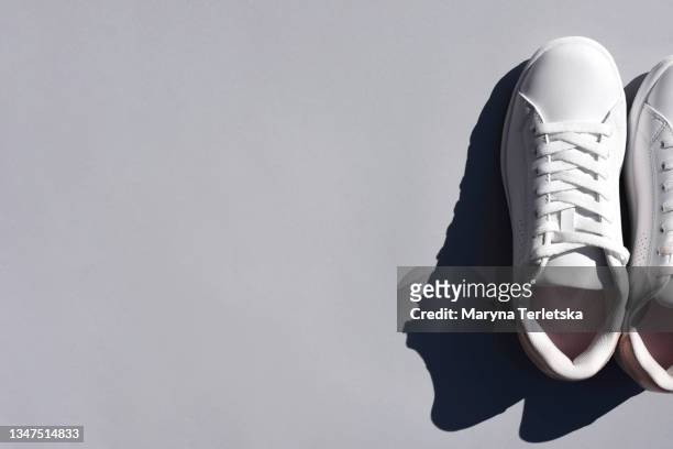 white sneakers on a colored background. - leather training shoes stock-fotos und bilder