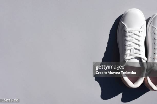 white sneakers on a colored background. - chaussures grises photos et images de collection