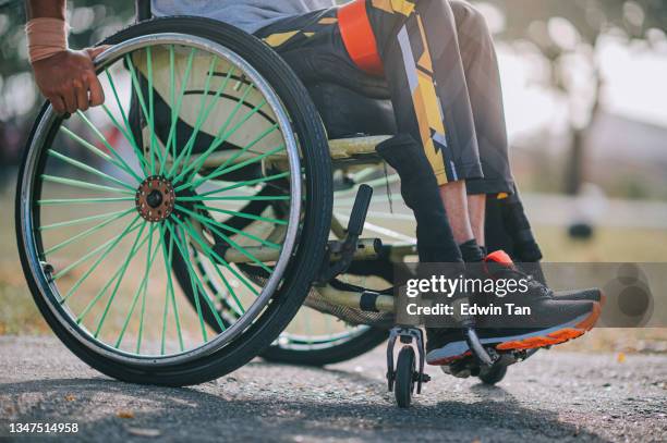 sección baja discapacitado hombre indio asiático en silla de ruedas haciendo ejercicio en el parque público entrenamiento deportivo de rutina por la mañana - training wheels fotografías e imágenes de stock