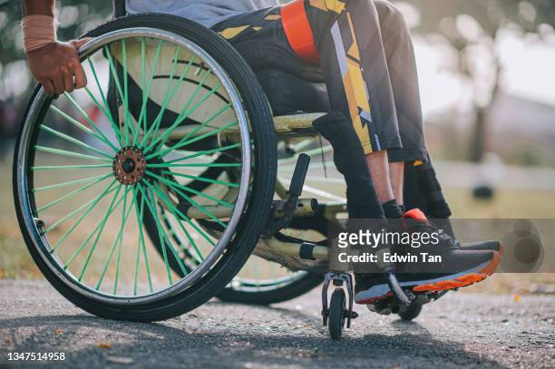 low section disabled asian indian man in wheelchair exercising in public park routine sport training in the morning - paralysis stock pictures, royalty-free photos & images