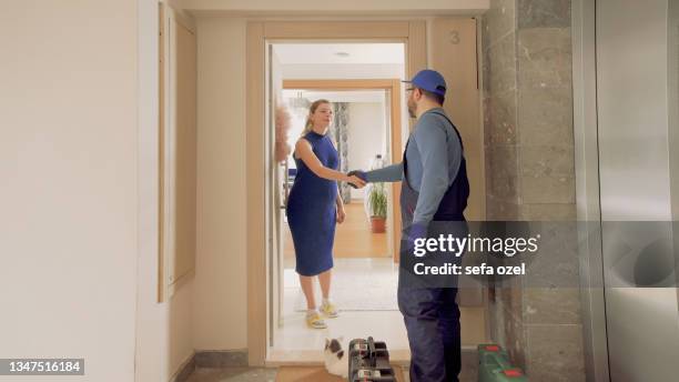 repairman handshake in house door - home repair stock pictures, royalty-free photos & images