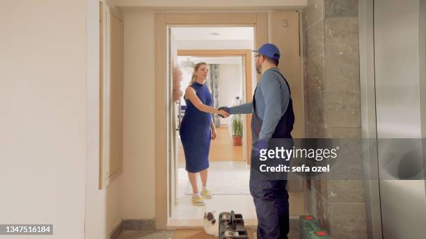 repairman handshake in house door - ventilador imagens e fotografias de stock