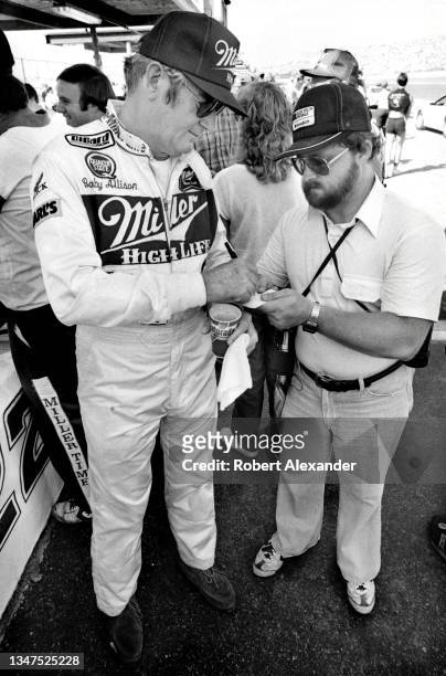 Driver Bobby Allison signs an autograph prior to the start of the 1984 Firecracker 400 stock car race at Daytona International Speedway in Daytona...