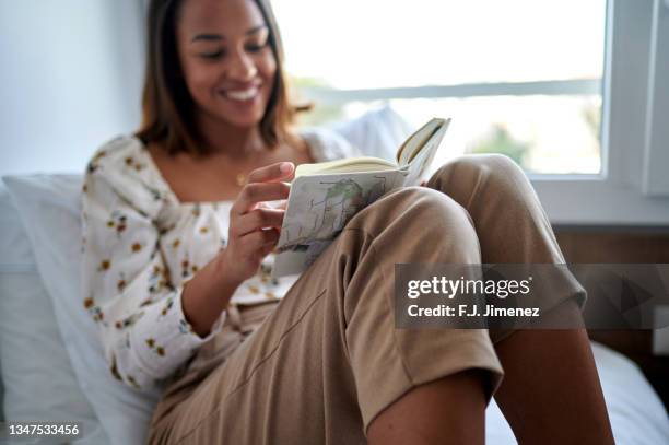 close-up of woman's hands with book in bed - j lee fotografías e imágenes de stock