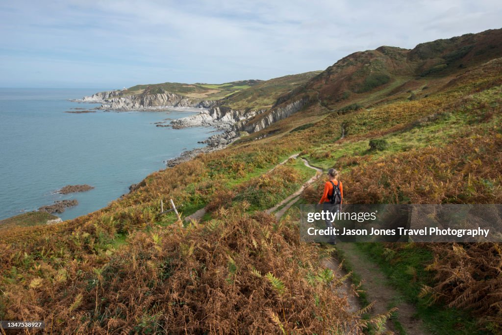 A person walks along the South West Coast Path in Devon