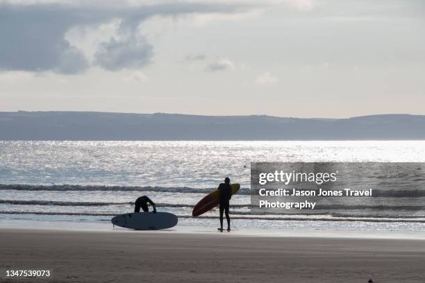 two surfers pack up on the beach in croyde - croyde beach stock pictures, royalty-free photos & images