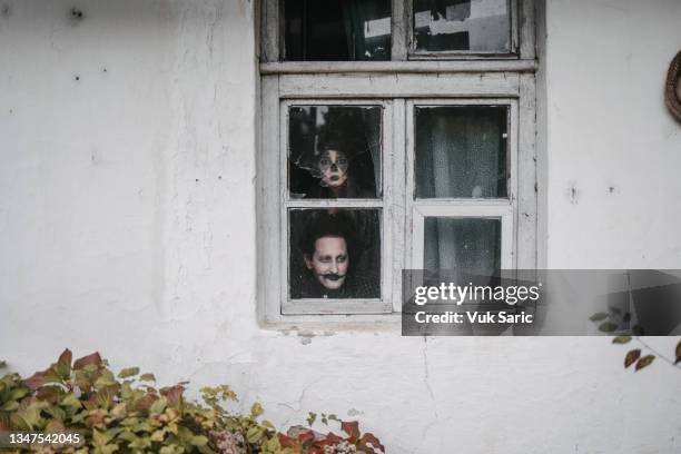 disguised man and a woman behind a broken window - peep window stock pictures, royalty-free photos & images