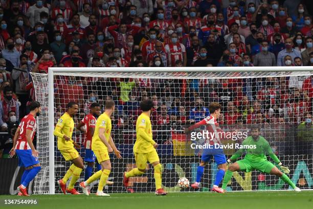 Alisson Becker of Liverpool fails to save a shot by Antoine Griezmann of Atletico Madrid as he goes on to score his side's first goal during the UEFA...